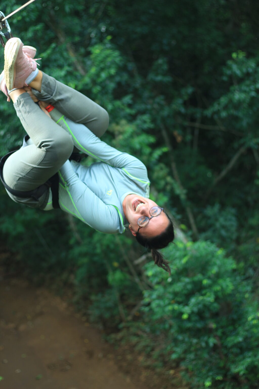 Woman ziplining upside down through the trees near Cancun