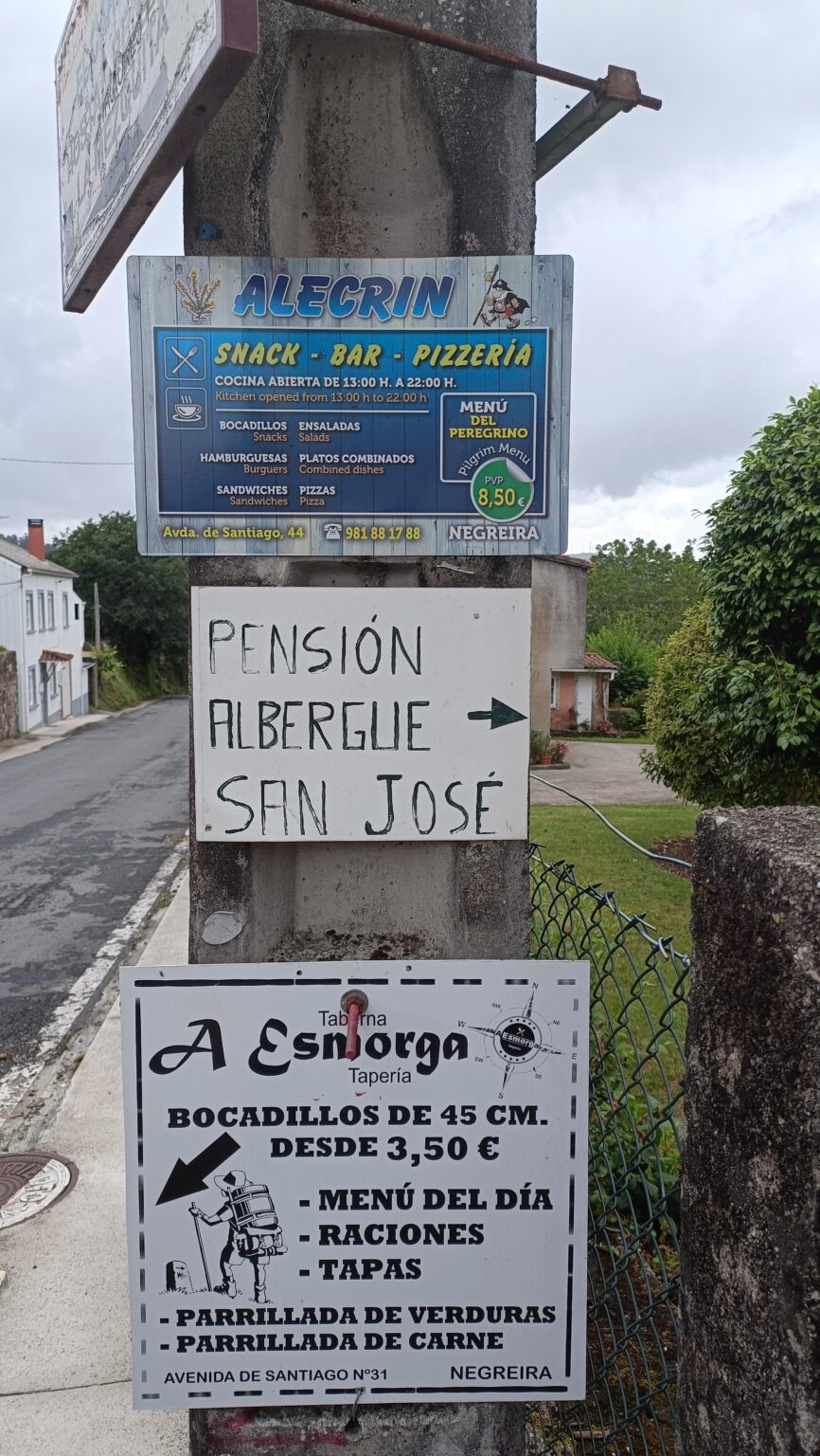 Signs for a pension and albergue along the Camino de Santiago