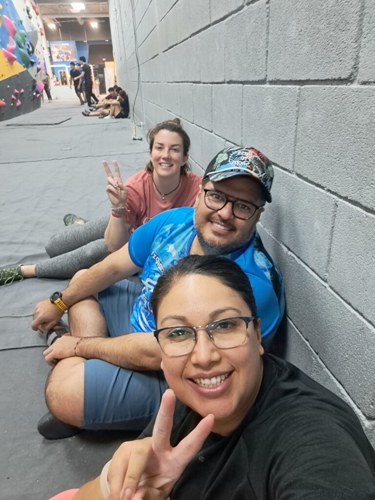 Two women and a man in a climbing gym