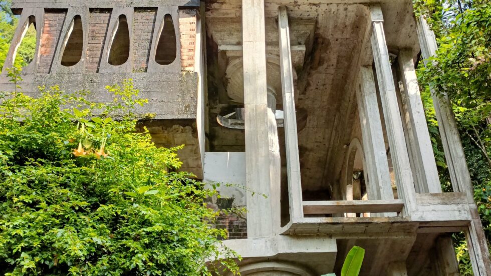 Tall concrete tower sculpture rising from the jungle at Las Pozas