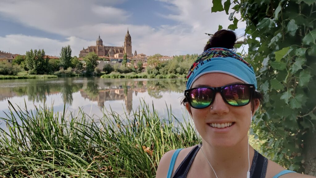 photo of hannah with a view of a building and a lake behind, in salamanca