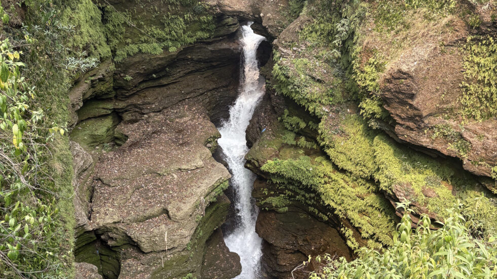 Waterfall dropping into a narrow mossy gorge in Pokhara