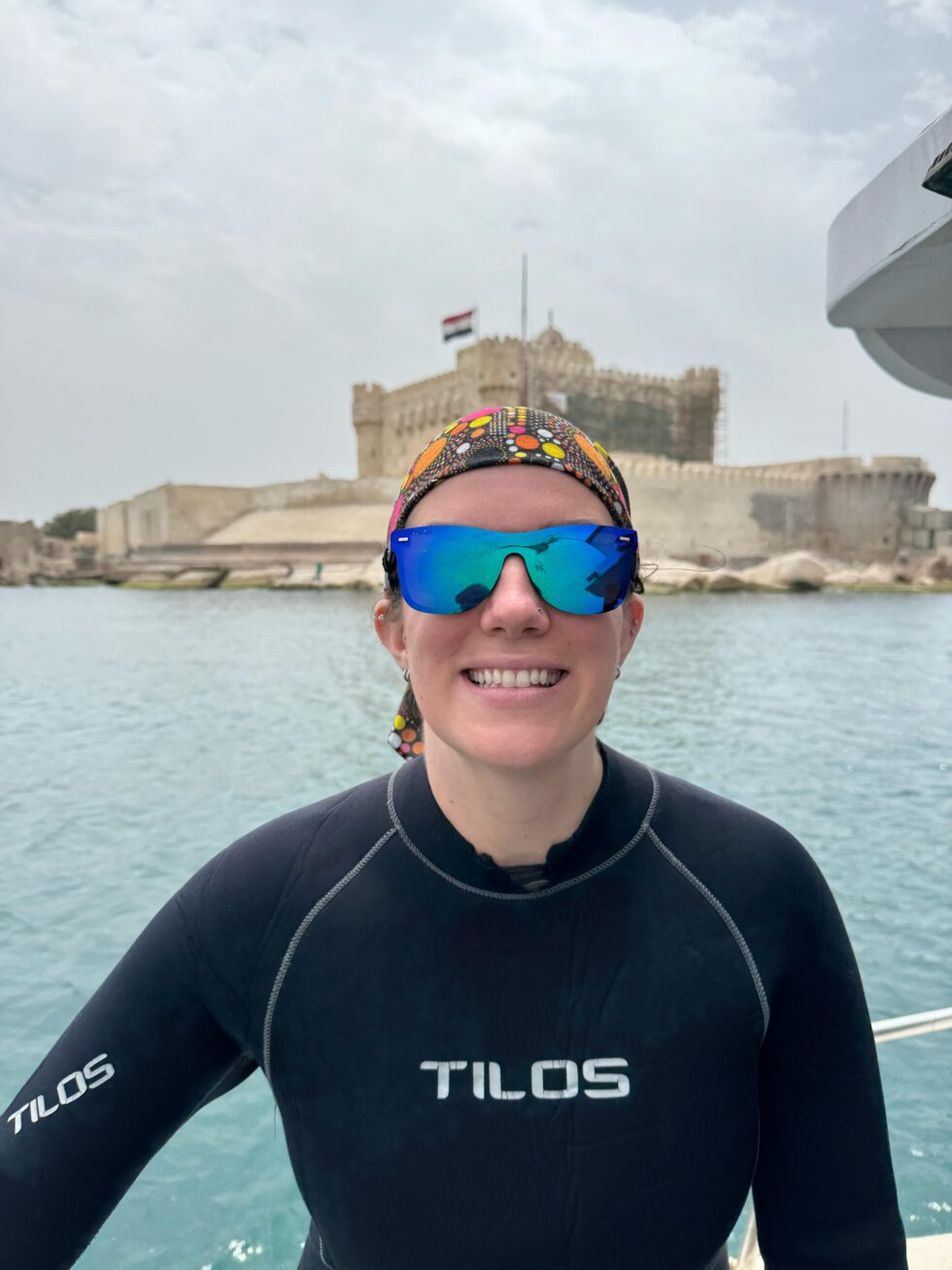 Hannah in a wetsuit on a boat near the Citadel of Qaitbay in Alexandria