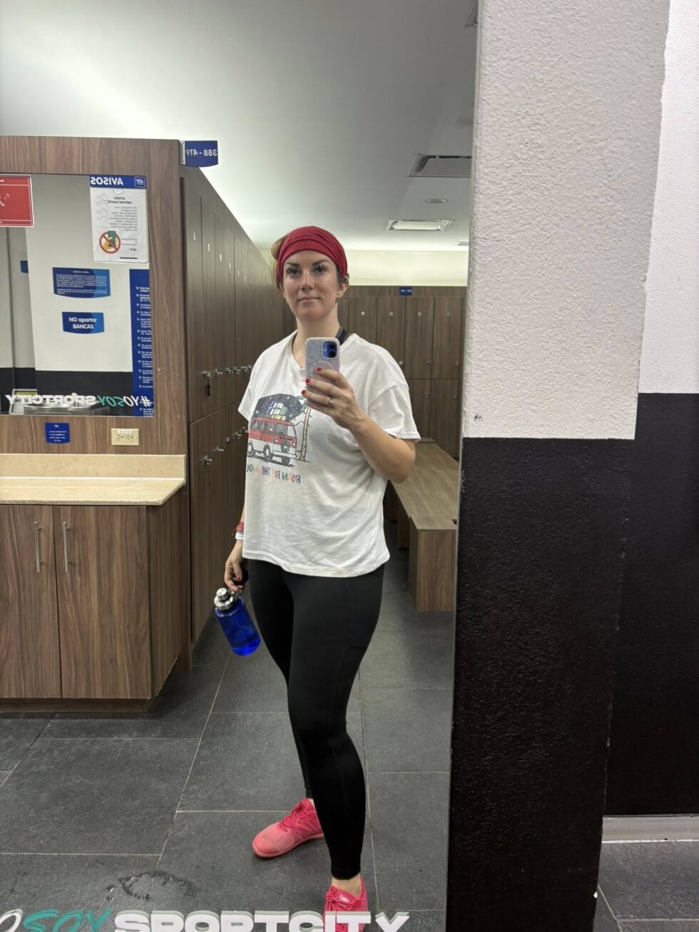 Hannah taking a mirror selfie in a gym locker room before a workout