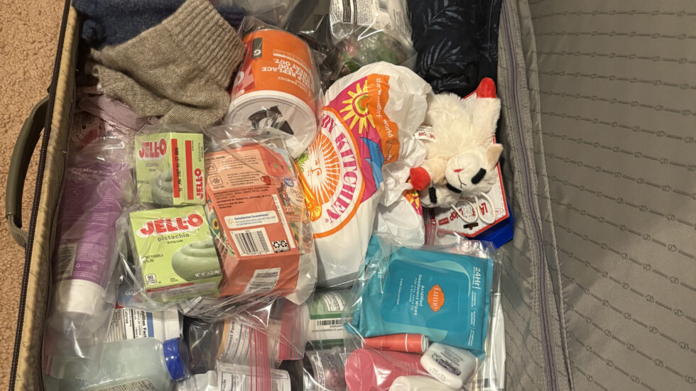 Open suitcase packed with American snacks and toiletries to bring back to Mexico