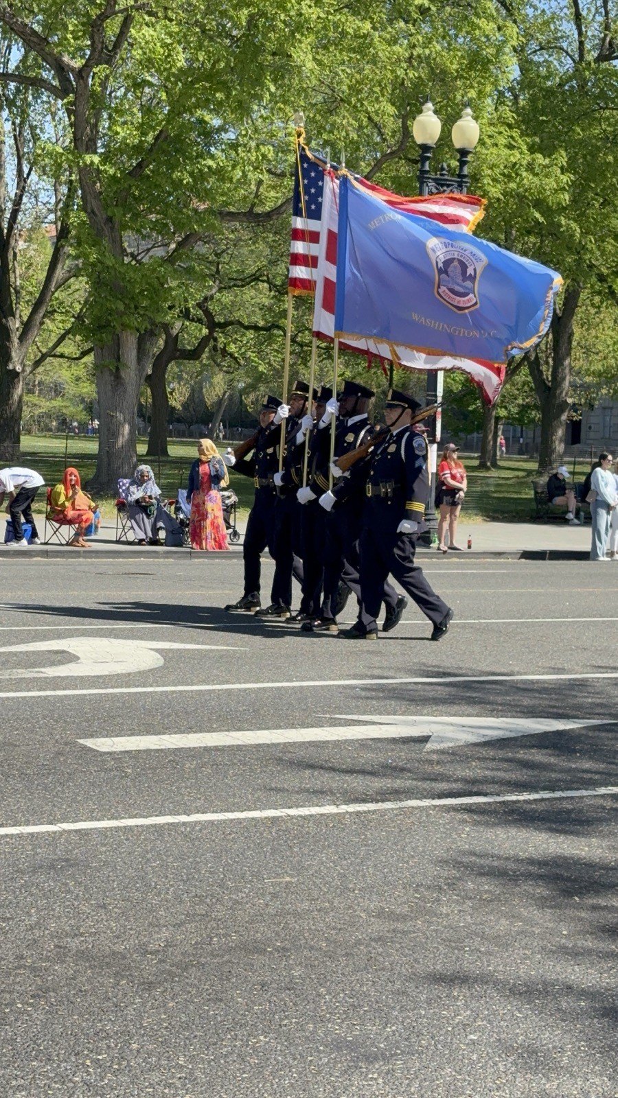 A color guard carrying the US flag and service flags down Constitution Avenue