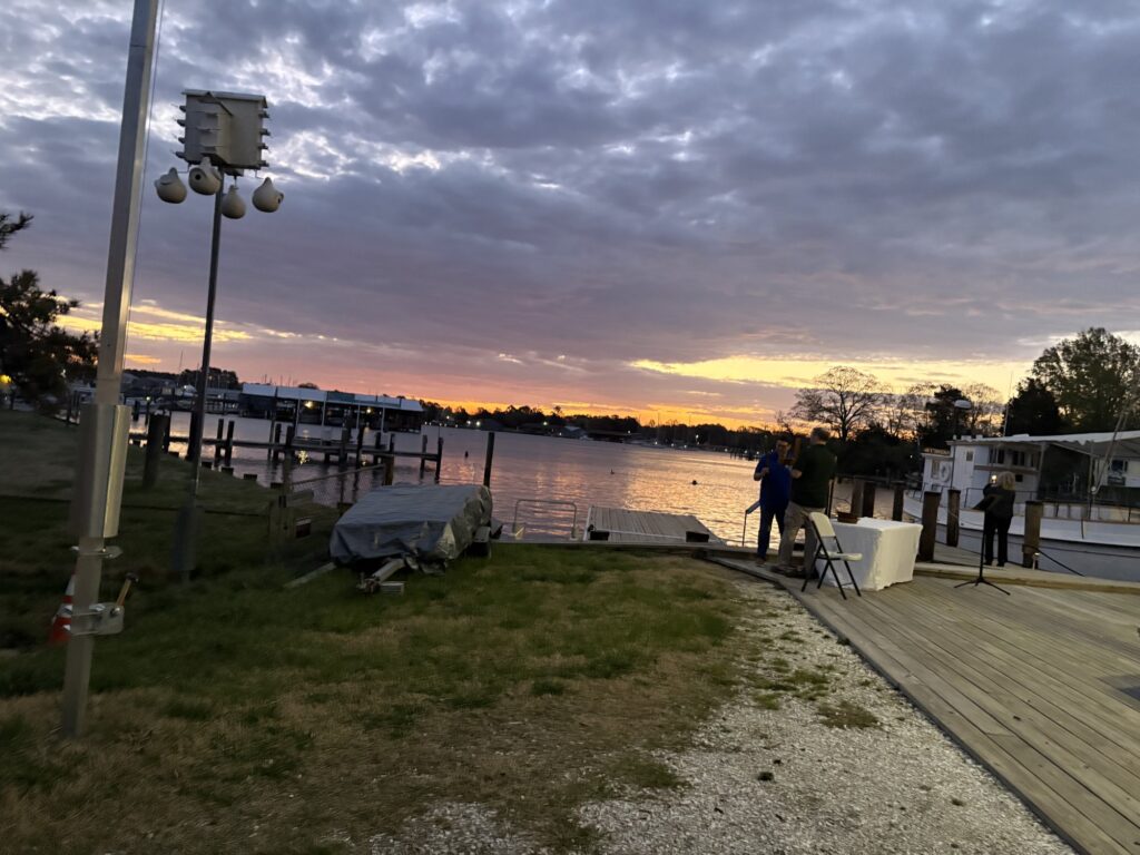Sunrise over Breton Bay at Leonardtown Wharf, with boats moored along the dock.