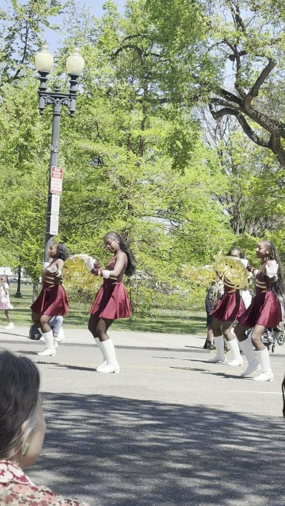 A marching band with majorettes in maroon uniforms on Constitution Avenue