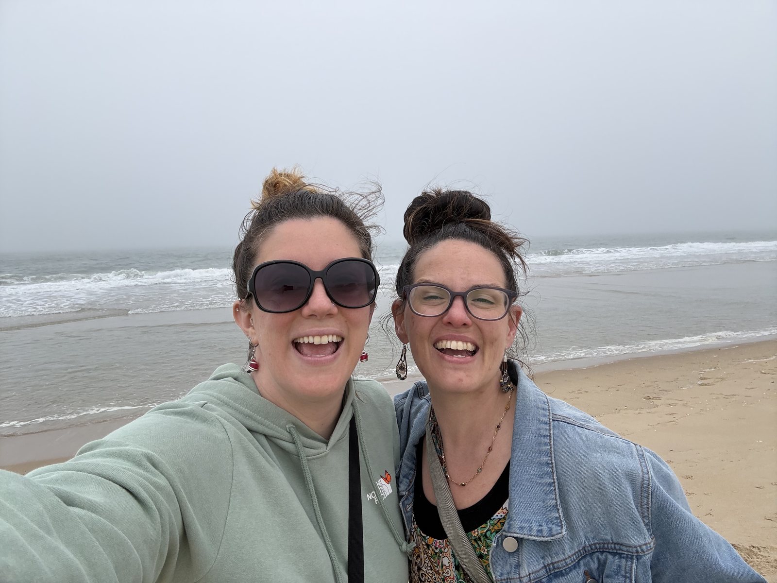 Two women taking a selfie on a foggy Ocean City beach in April