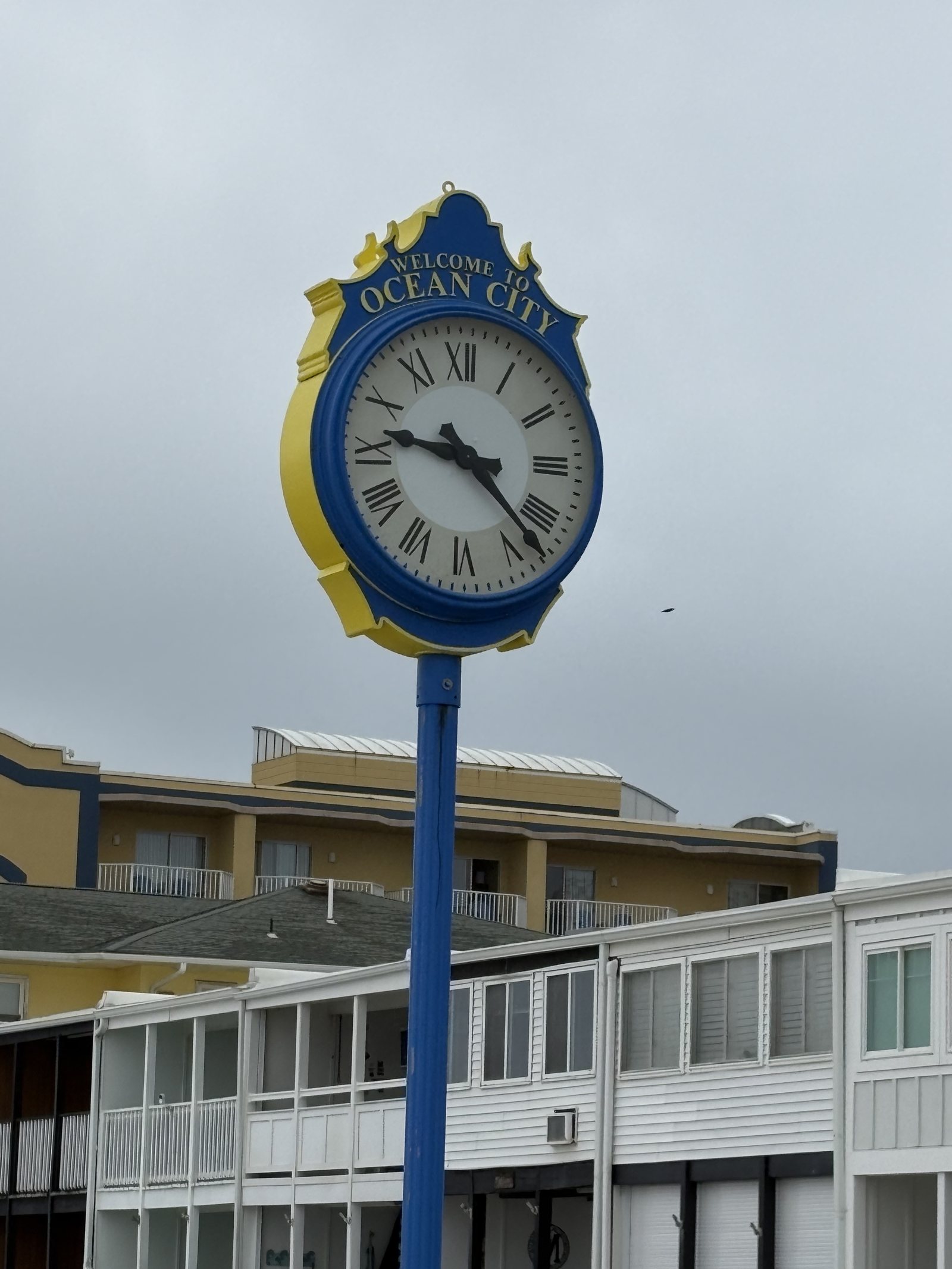The blue and gold Ocean City clock standing over the boardwalk under a grey sky