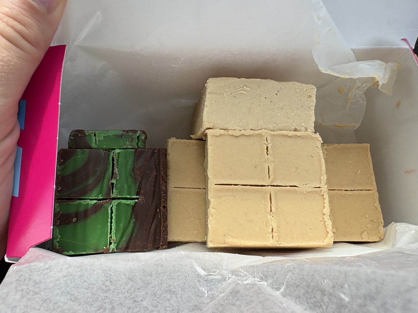 Blocks of homemade fudge in a pink boardwalk candy box