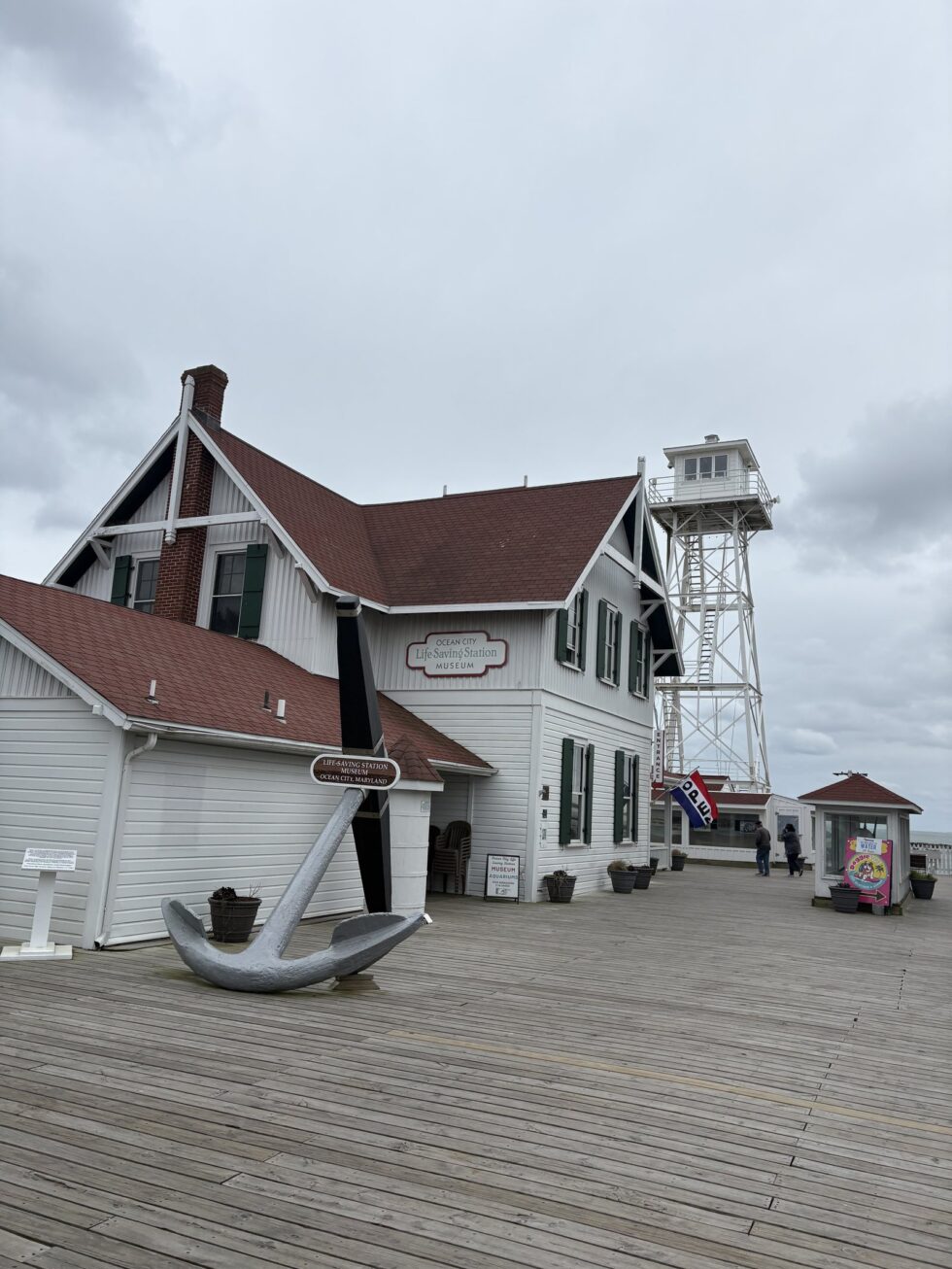 The white Ocean City Life-Saving Station Museum with its anchor and lookout tower at the end of the boardwalk