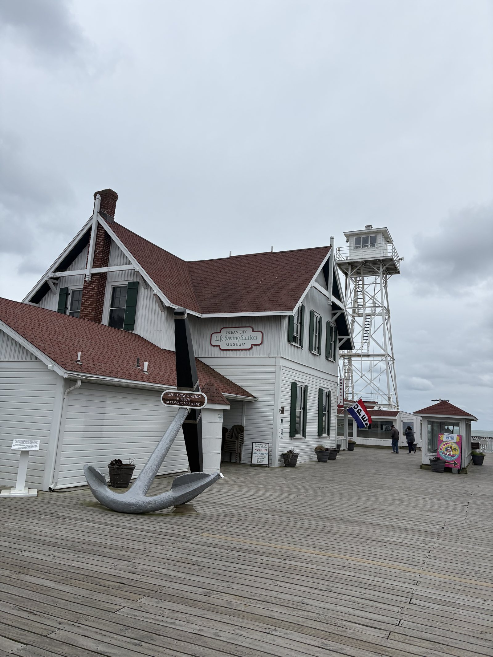 The white Ocean City Life-Saving Station Museum with its anchor and lookout tower at the end of the boardwalk