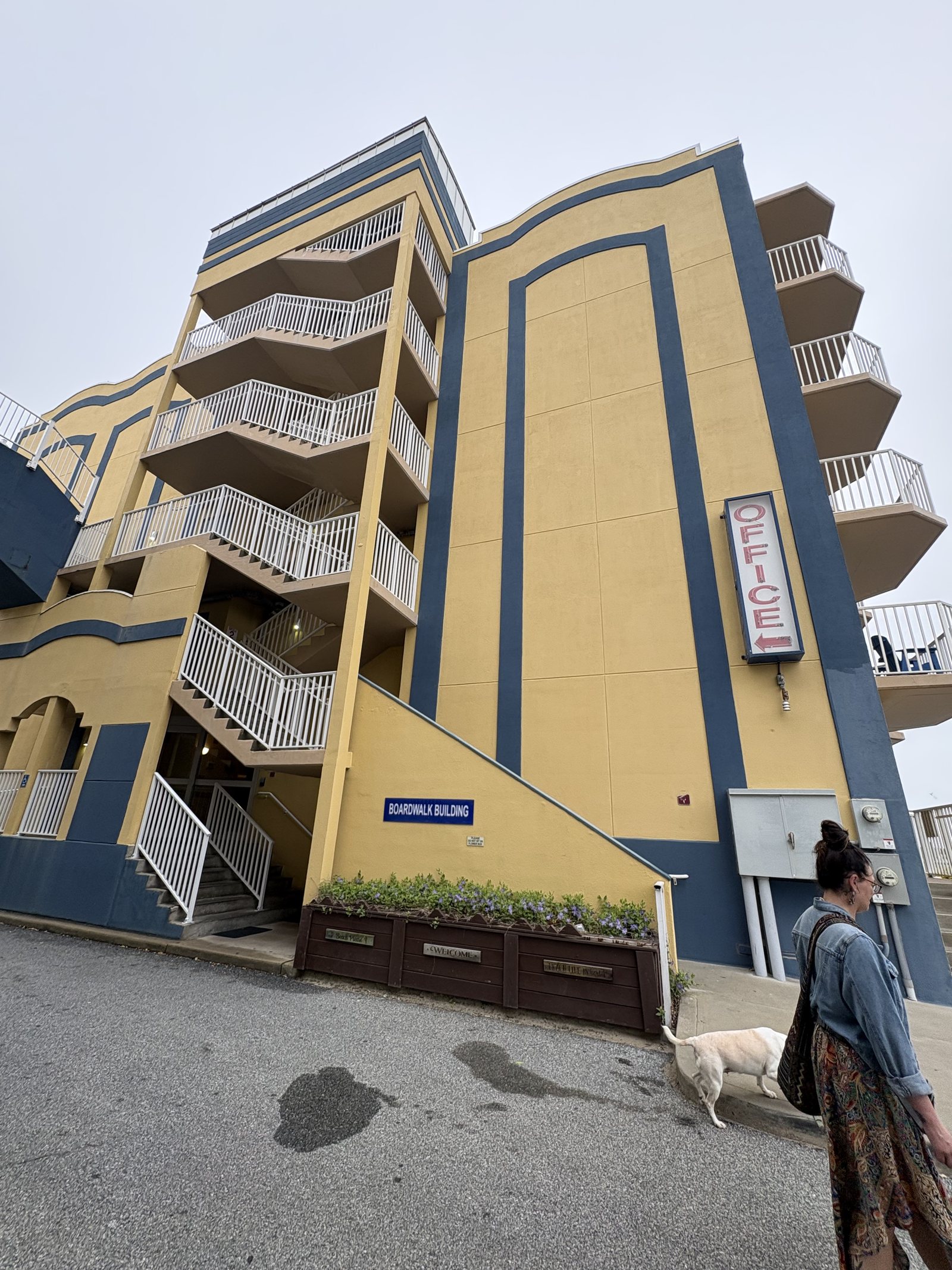 A yellow and blue oceanfront hotel on the Ocean City boardwalk on an overcast day